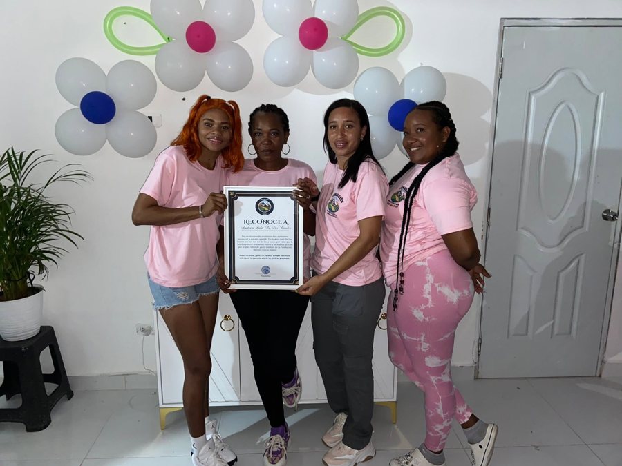 Cuatro voluntarias de la fundación sostienen un reconocimiento enmarcado