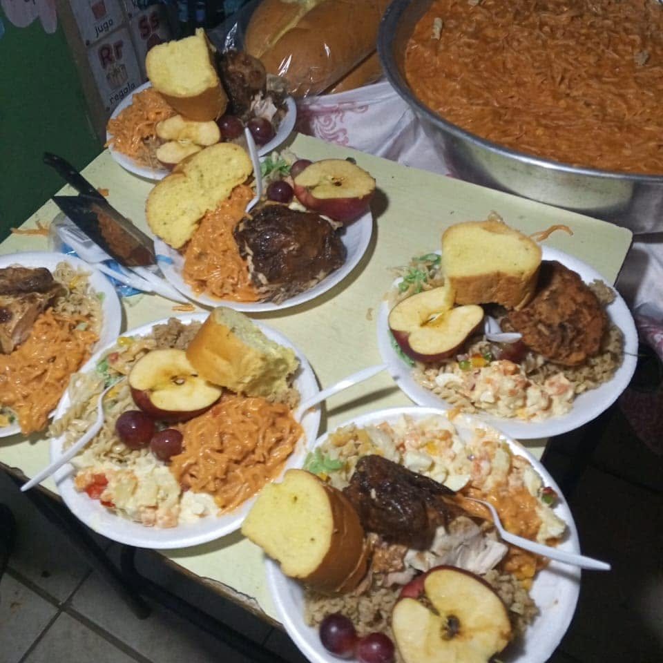 Platos de comida servidos con arroz, pasta, pollo, pan y fruta