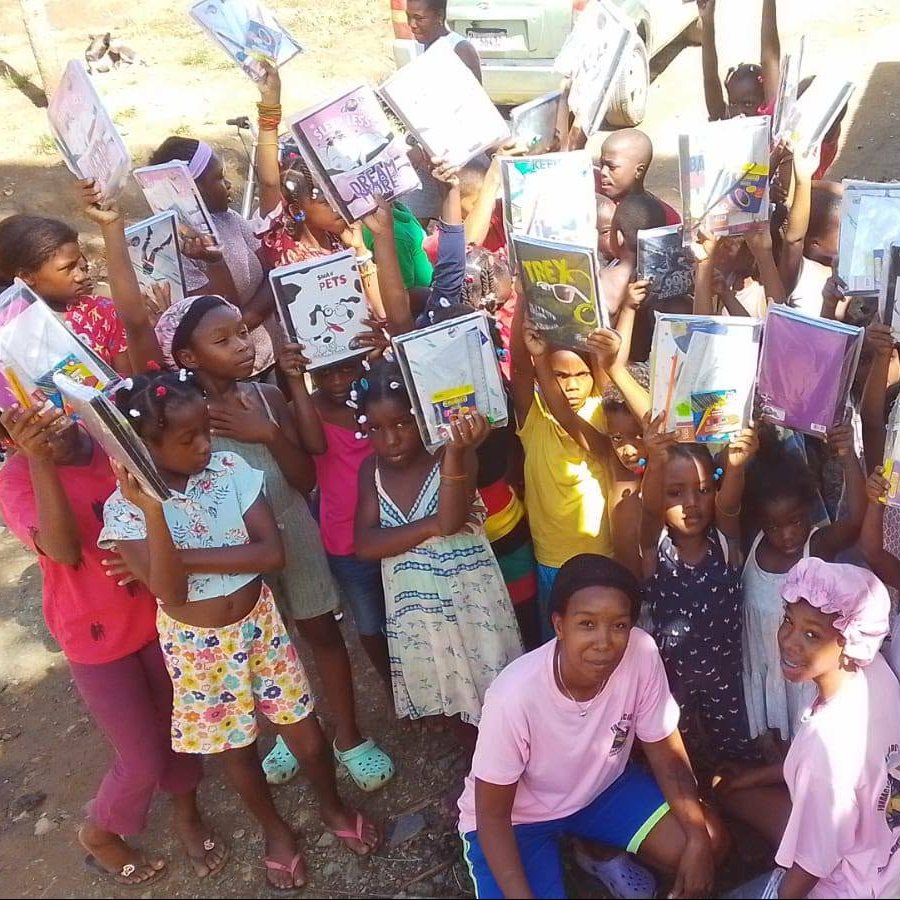 Grupo de niños y niñas mostrando sus cuadernos y útiles escolares nuevos