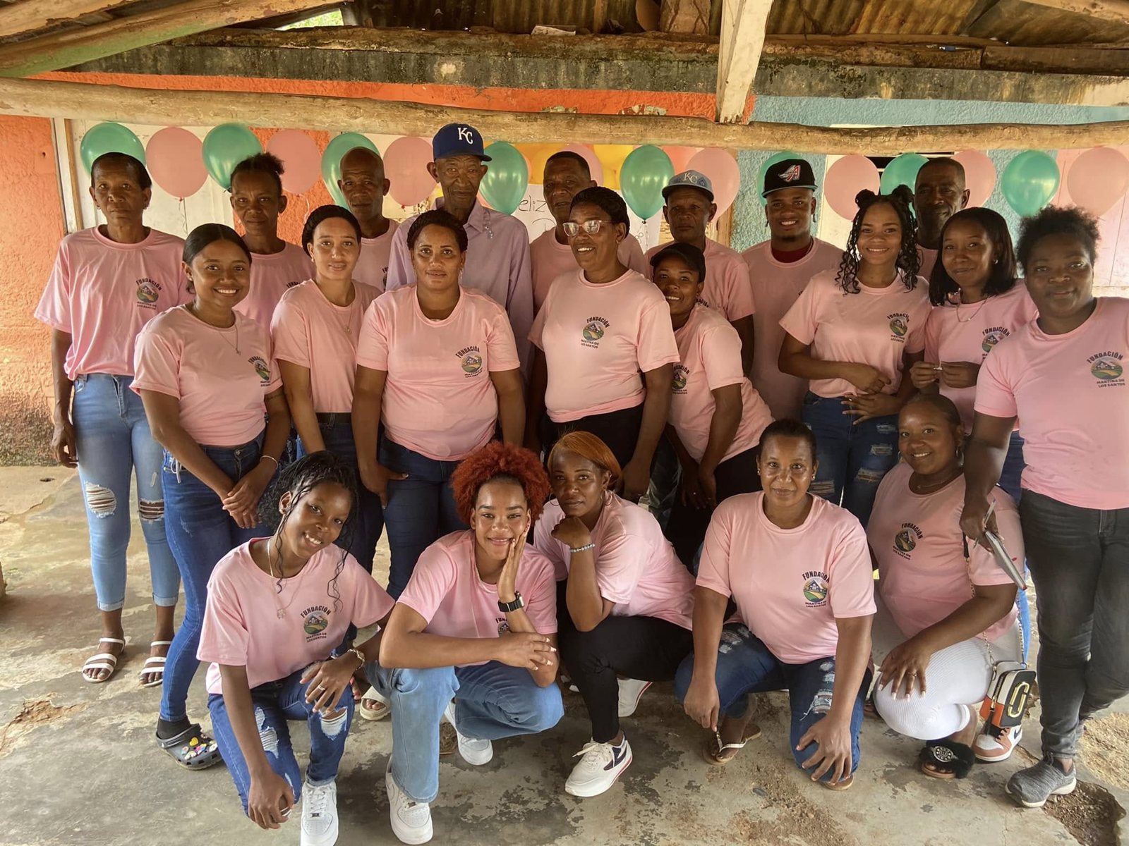 Equipo de voluntarios de la fundación, sonrientes, con sus camisetas rosadas y el logo